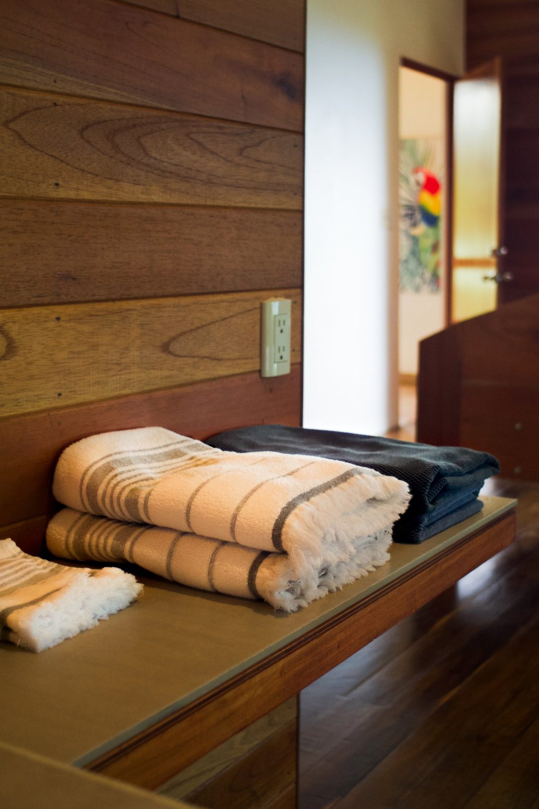 Folded striped towels on a wood bench