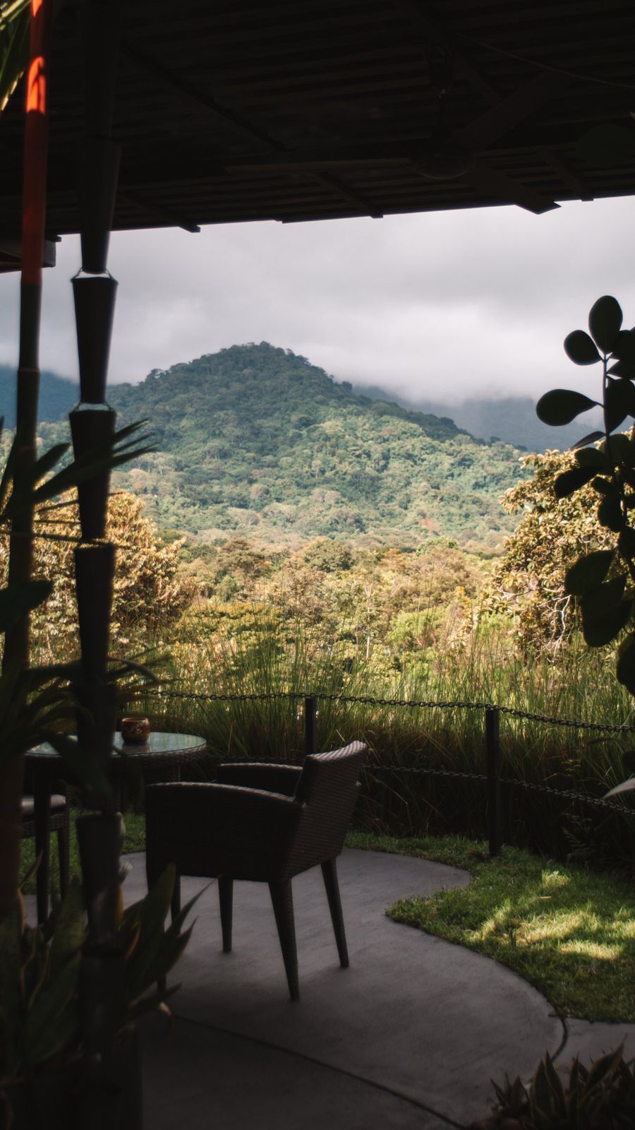Covered patio with wicker seating facing the mountain view