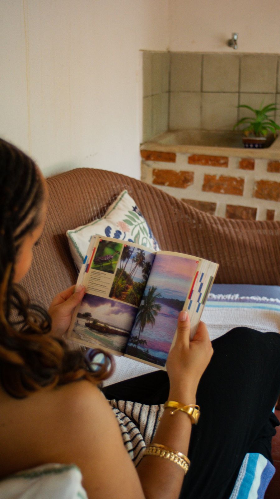 Guest reading a Costa Rica guidebook on a wicker sofa