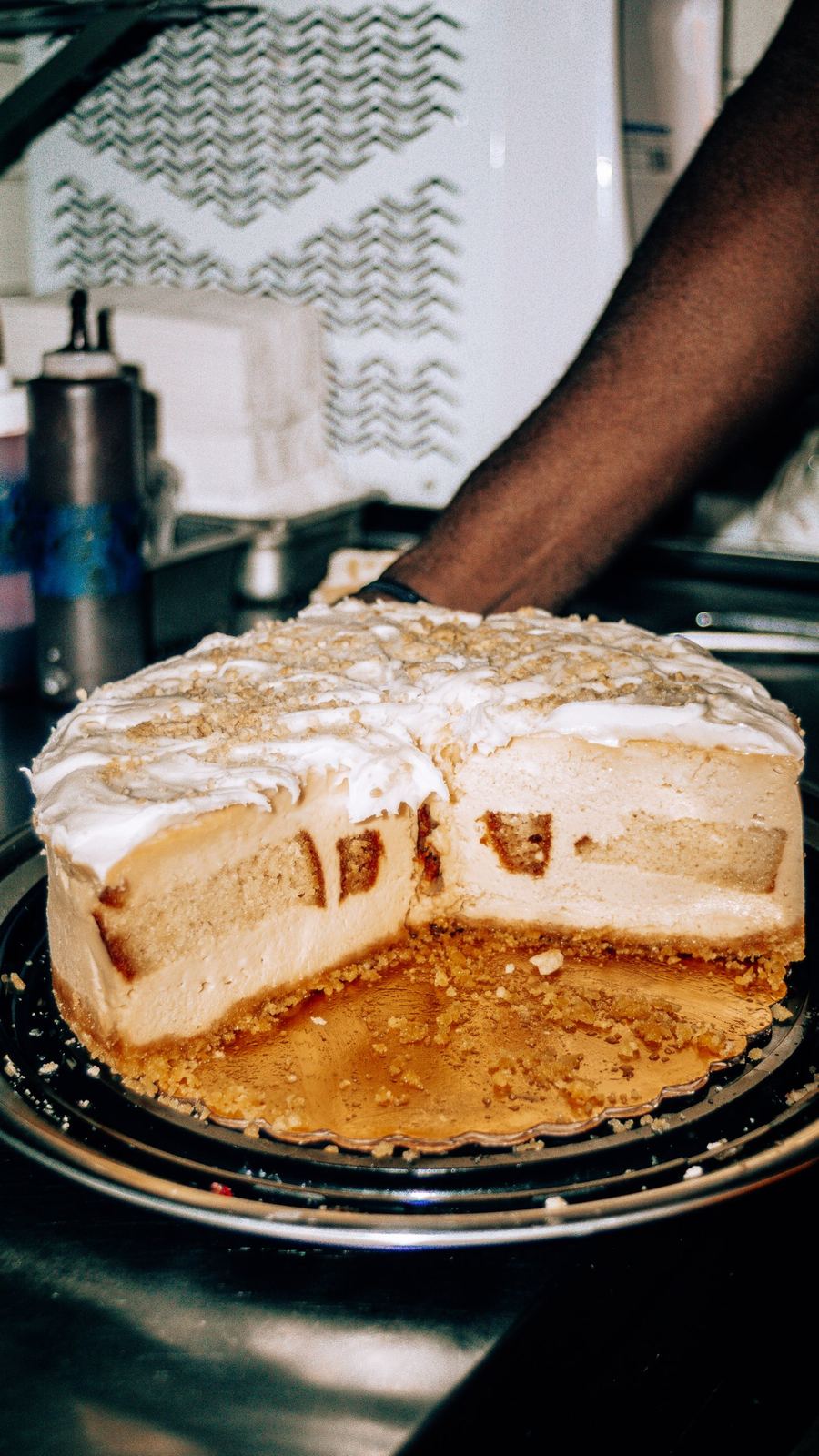 Frosted cheesecake cut open to show its cake-layered center