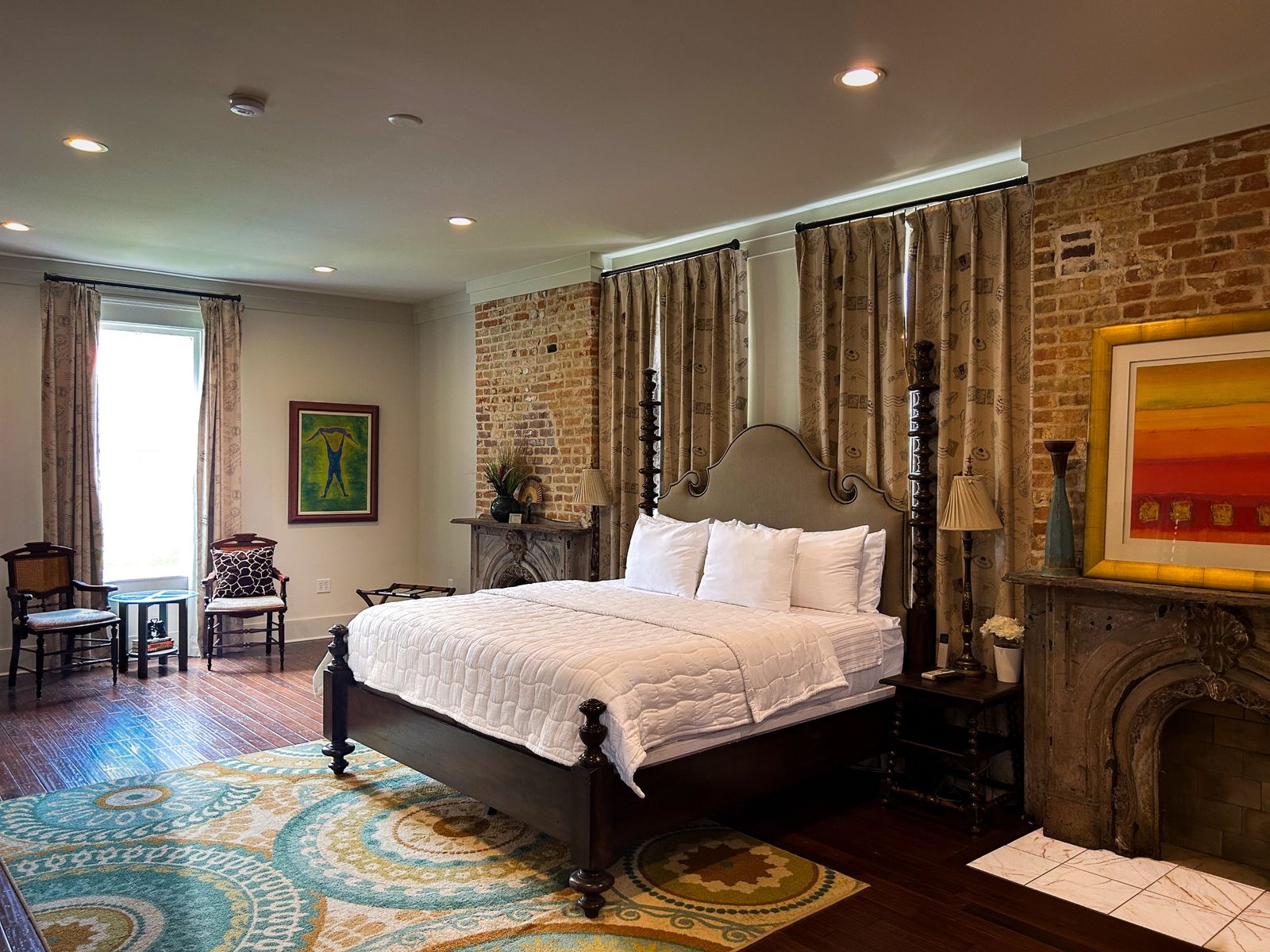 Suite with a four-poster bed, exposed brick and carved stone fireplaces
